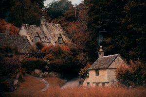 A windy road in the Cotswolds lined with cottages on an autumn day - a perfect weekend escape in rural England.